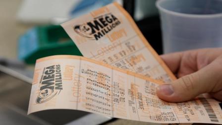 Scott Hoormann holds two Mega Millions lottery tickets he purchased at Energy Express Monday, Dec. 16, 2013, in St. Louis. The Mega Millions jackpot now stands at an estimated $636 million with the next drawing set for Tuesday night.