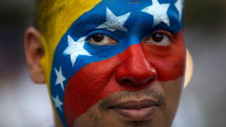 David Aranguren, his face painted with a representation of Venezuelas national flag, poses for a photo during an anti-government demonstration in Caracas, Venezuela, Saturday, Feb. 22, 2014.
