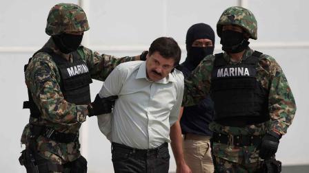 Joaquin El Chapo Guzman is escorted to a helicopter in handcuffs by Mexican navy marines at a navy hanger in Mexico City, Mexico, Saturday, Feb. 22, 2014.