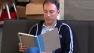 Man using tablet that has a case that disguises it as a book