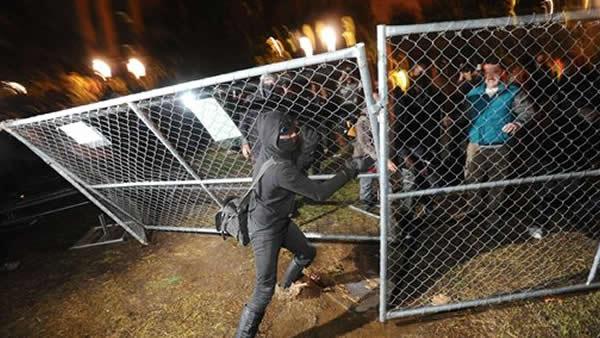 Occupy Oakland protester tears down a fence
