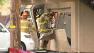Investigators look at burned home after standoff