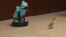 Cat In A Shark Costume Chases A Duck While Riding A Roomba