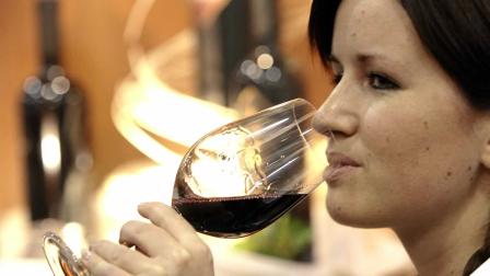 A woman drinking a glass of red wine.