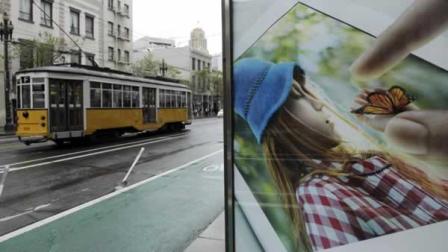 In this photo taken Thursday, May 3, 2012, an old streetcar passes a display for an Apple iPad near Twitters new headquarters in San Francisco.