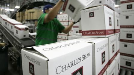 A worker stacks cases of Charles Shaw wine
