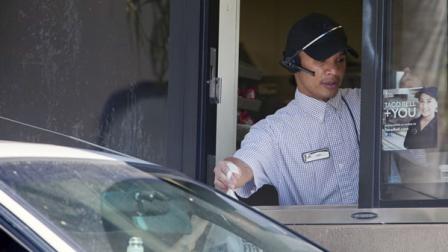 A Carls Jr. employee gives a customer their order through a drive-thru window in San Diego on Friday, Sept. 13, 2013. (AP Photo/Sam Hodgson)