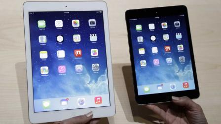 An Apple employee demonstrates the new iPad Air, left and iPad mini on Tuesday, Oct. 22, 2013, in San Francisco. Apple unveiled a new, thinner, lighter tablet called the iPad Air along with a slew of new Macs Tuesday at an event in San Francisco.