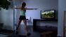 A woman exercises while playing the Nintendo Wii.