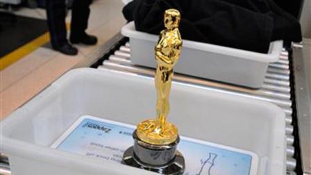 An Oscar statue waits as Academy of Motion Picture Arts and Sciences president Tom Sherak goes through security before boarding Oscar One heading to Los Angeles for the Academy Awards ceremony, at OHare International Airport in Chicago.