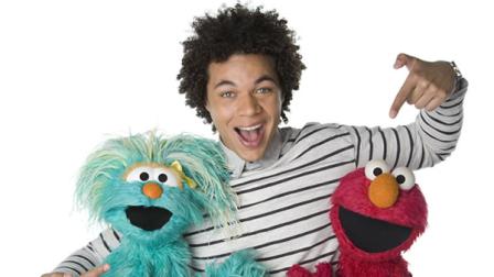 This April 2013 photo released by Sesame Workshop shows Puerto Rican actor Ismael Cruz Cordova, 26, of Sesame Street, posing with muppets Rosita, left, and Elmo in New York.