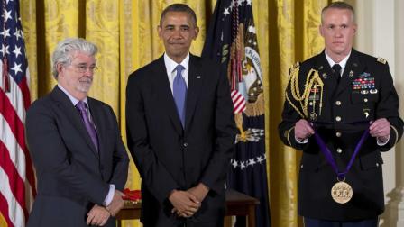 President Barack Obama stands with director George Lucas as he awards him the 2012 National Medal of Arts during a ceremony in the East Room of White House.