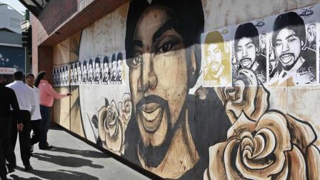 People react in front of posters of Oscar Grant in Oakland, Calif., after a guilty verdict for Johannes Mehserle, Thursday, July 8, 2010.
