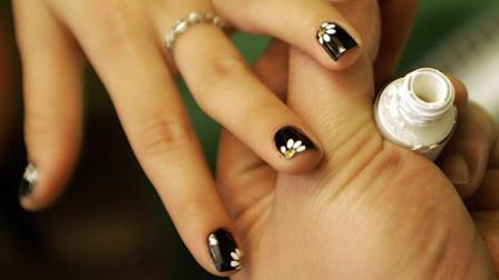 Nail technician Leo Nguyen paints nails of his customer Du Mai Anh at Nails 28
