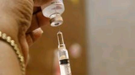 A public health nurse demonstrates drawing flu vaccine from a bottle