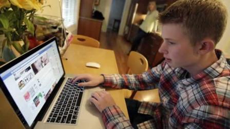 In this Oct. 24, 2013 photo, Mark Risinger, 16, checks his Facebook page on his computer as his mother, Amy Risinger, looks on at their home in Glenview, Ill. The recommendations are bound to prompt eye-rolling and LOLs from many teens but an influential pediatricians group says unrestricted media use has been linked with violence, cyber-bullying, school woes, obesity, lack of sleep and a host of other problems. Marks mom said she agrees with restricting kids time on social media but that deciding on other media limits should be up to parents. (AP Photo/Nam Y. Huh)