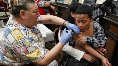 Darrell Taylor, 9, reacts as he receives a flu vaccination from Geneva Hill, a licensed vocational nurse, during a free flu vaccine clinic at the Capitol in Sacramento, Calif., Monday, Jan. 28 , 2013