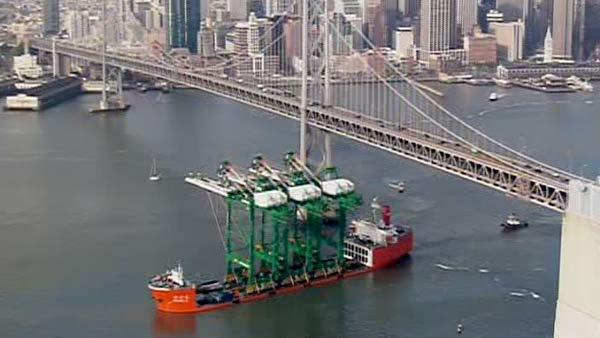 A ship carrying three new container cranes passed under the Bay Bridge.