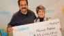 Massoud Ardalan and his wife Homeira pick up their SuperLotto Plus jackpot check.