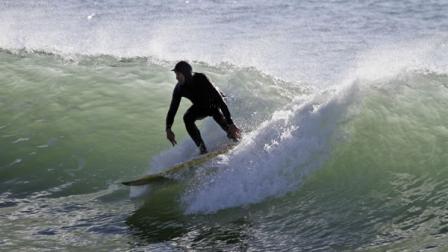 A surfer rides a wave in Half Moon Bay, Calif., near the site of the famous Mavericks big wave surf contest.