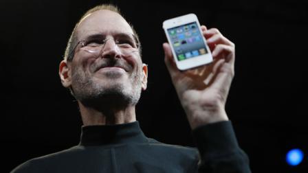 The late Apple CEO Steve Jobs holds a new iPhone at the Apple Worldwide Developers Conference in San Francisco.