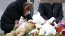 A woman pays her respects at a makeshift memorial outside St. Rose of Lima Roman Catholic Church before Mass, Sunday, Dec. 16, 2012, in Newtown, Conn.