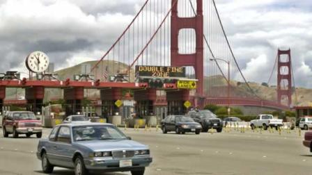 Vehicles drive in front of a line of toll booths after crossing the Golden Gate Bridge.
