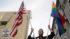 Billy Bradford carries an American flag and a...