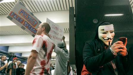 An unidentified protester uses his cell phone during a protest at the Civic Center BART station in San Francisco, Monday, Aug. 15, 2011.