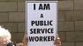 public service worker holds sign