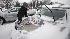 Bob Bryson clears snow from his wifes car in...