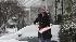 Rose Skore shoves snow in front of her home in...