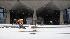 Workers shovel snow during a winter storm,...
