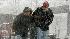 A couple walks against blowing snow Saturday,...