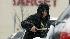 As snow falls, a man clears his car in at a...