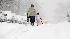 Pedestrians navigate snow-covered city streets...