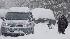 A resident digs a path for his car through the...