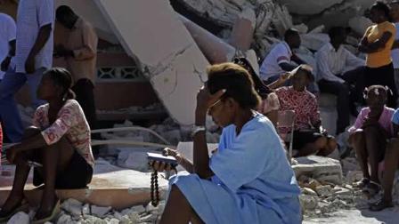 A woman prays aside the rubble of a collapsed church in Port-au-Prince.