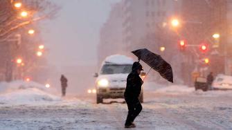 A pedestrian navigates the snow covered streets of downtown Washington.