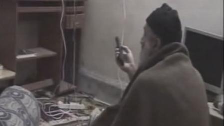 A man who the American government says is Osama bin Laden watches television.