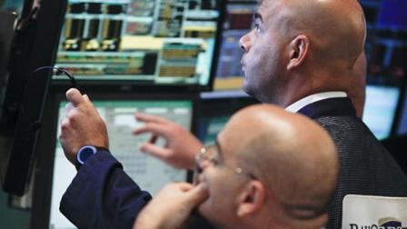 Traders work at the start of early trading at the New York Stock Exchange. U.S. stocks slid for a sixth day.