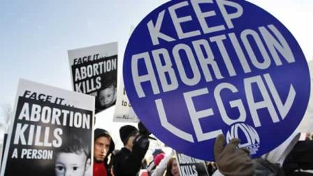 In this Monday, Jan. 24, 2011 file picture, anti-abortion and pro-choice activists stand next to each other in front of the U.S. Supreme Court in Washington during a rally on the anniversary of the Roe v. Wade decision.