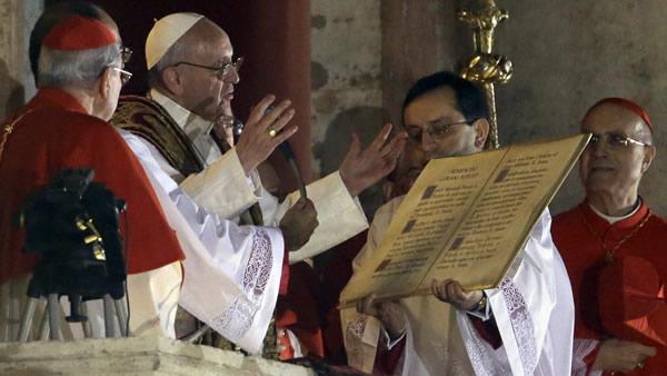 Pope Francis speaks from the central balcony of St. Peter's Basilica at the Vatican, Wednesday, March 13, 2013