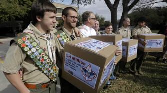 File photo James Oliver, left, hugs his brother and fellow Eagle Scout, Will Oliver, who is gay, as Will and other supporters carry four boxes filled with a petition in front of the Boy Scouts of America headquarters, in Dallas, Texas