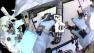 In this image made from video provided by NASA, astronaut Christopher Cassidy, foreground, holds a power wrench as he stows away a suspect coolant pump on the International Space Station on Saturday, May 11, 2013