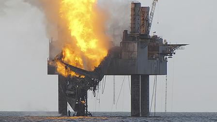 In this Wednesday, July 24, 2013 photo released by the U.S. Coast Guard, abatement efforts underway near Hercules 265 Rig where fire has caused collapse of the drill floor and derrick following an explosion Tuesday night.