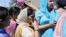 Bystanders stand outside the scene of a shooting at the Milwaukee-area Sikh temple in Oak Creek, Wis.