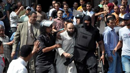 Egyptians security forces escort an Islamist supporter of the Muslim Brotherhood out of the al-Fatah mosque, after hundreds of Islamist protesters barricaded themselves inside the mosque overnight