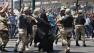 Egyptian security forces escort supporters of the Muslim Brotherhood, center, out of the al-Fatah mosque and through angry crowds, in the background, in Ramses Square, downtown Cairo, Egypt, Saturday, Aug. 17, 2013.