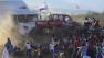 People run as an out of control monster truck plows through a crowd of spectators at a Mexican air show in the city of Chihuahua